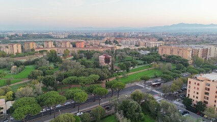 Aerial view of Rome's urban landscape with green parks and residential buildings during sunset