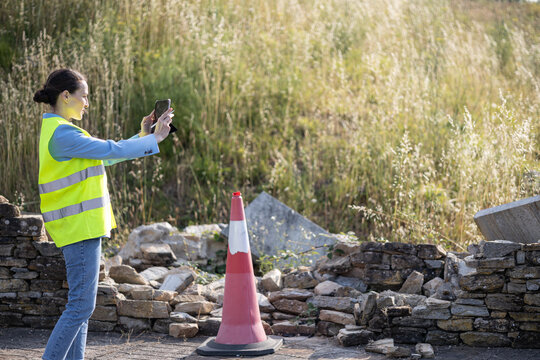 Insurance claims adjuster taking a photo and evaluating damage after incident