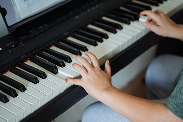 A person is skillfully playing a beautiful piano, their hands gracefully positioned over the gleaming keys, creating enchanting music that fills the air with joy and emotion