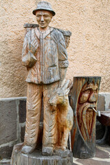 Statue di legno di montanaro con cappello gerla e cerbiatto con gnomo con pipa
