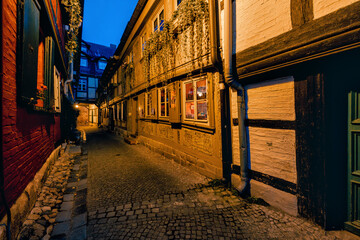 Typische Gasse mit gepfasteter Strasse zwischen sehr alten Fachwerkhäusern hindurch in Quedlinburg.