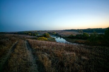 Obraz premium Dirt road through a field in the early morning