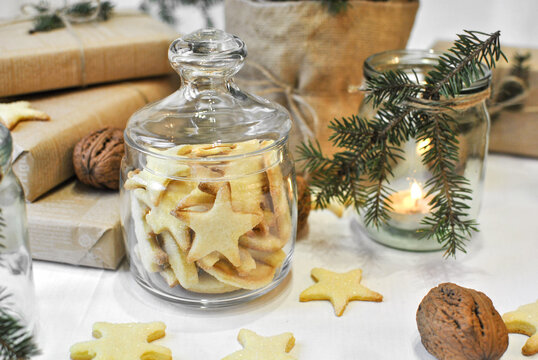 A glass jar with shortbread homemade cookies, next to the Christmas decor, a festive atmosphere. Family traditions, preparation for the new year.