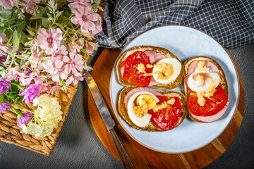 Sandwich with ham, eggs and tomato.