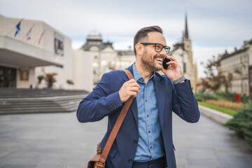 Smile businessman talk on mobile phone while go to work