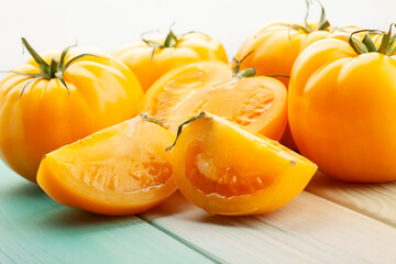 sliced yellow tomato on wood background