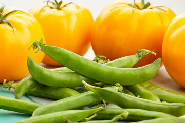 green peas yellow tomato on wood