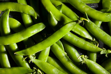 green peas on black wood background