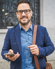 Adult businessman walk around city and use mobile phone