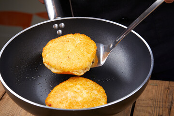 chef making potato pancakes in kitchen