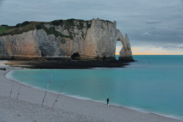 Trou de l'Homme Cave, Falaise d'Aval Cliff, Porte d'Aval Arch, Aiguille Creuse Needle, colorful sunset sky, fisherman in the beach. Etretat-France-019