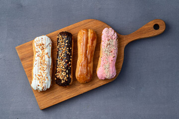 Assorted eclairs on a pastel top view Traditional French dessert