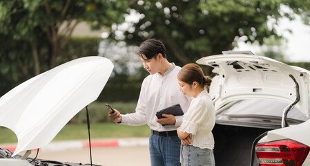 roadside assistance: Couple with car trouble seeking help from roadside assistance professional
