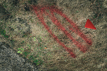 abstract spray painted red utlity marking on grass with flag background