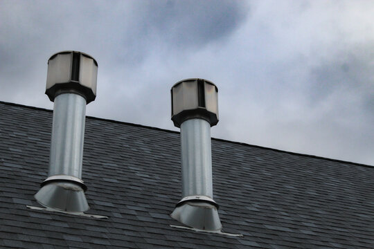 close-up of two roofing vents with metal flashing construction background