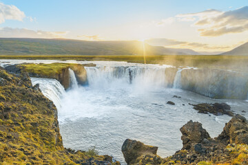 Majestic Goðafoss waterfall at sunset, with cascading waters of the Skjálfandafljót River, in northern Iceland.