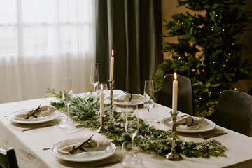 High angle shot of served festive table in decorated dining room for Christmas party