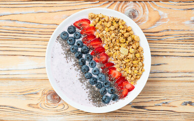 Healthy breakfast . Yogurt with berries ( strawberry , raspberry , blueberry , blackberry ) , granola and chia seeds . Top view
