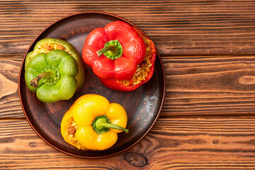 Baked stuffed pepper ( paprika ) with rice , carrot and meat . Top view on rustic background