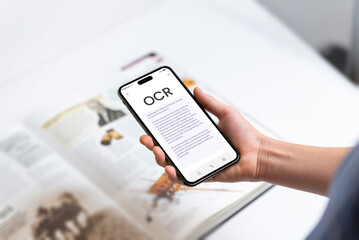 Smartphone with OCR app instantly scanning and digitizing book text, symbolizing modern technology's ability to bring printed words to life through real-time text recognition