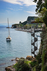 Obraz premium Old spiral staircase in The Garden of the People with view to Mandraki harbour and the Old Fortress in Corfu, Greece.