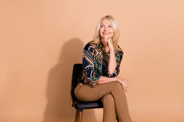 Photo of blonde mature age business woman in stylish shirt touch chin sitting thoughtful looking...