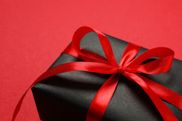 Beautiful gift box tied with bow on color background 