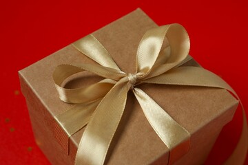 Beautiful gift box tied with bow on color background 