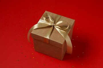 Beautiful gift box tied with bow on color background 