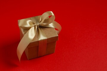 Beautiful gift box tied with bow on color background 