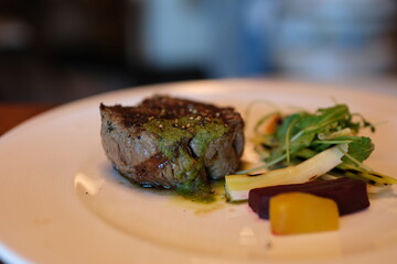 Filet Mignon Delicious juicy beef steak is fried on a red-hot grill. Close-up of fillet mignon beef steak cooking on a hot grill. Meat, beef steak, sprig of rosemary, spray of hot oil. Macro