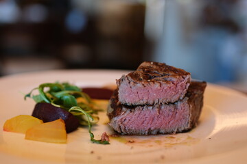 beef medium Chef with Vintage Knife Cuts of Grilled Beef Steak on Rustic Cutting Board on Wooden Background. Juicy Sliced Rib Eye Steak with Salt. Concept of Delicious Meat Food
