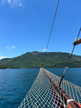 A proa de uma escuna com rede navegando para ilha grande