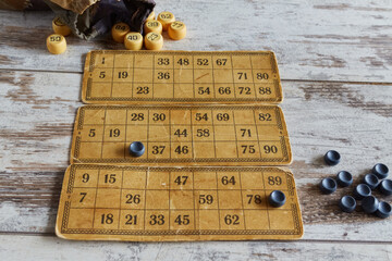 Vintage bingo on a wooden table, old bingo game cards on a worn table, traditional home board game...