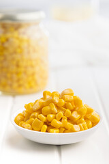 Canned sweet corn in bowl on white table.