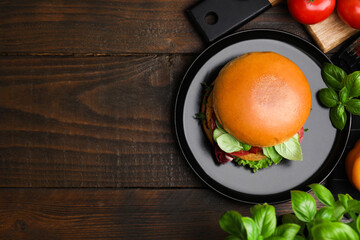 Delicious vegan burger with chickpea cutlet on wooden table, flat lay. Space for text