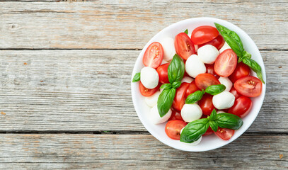 Basil leaves , cherry tomatoes and mozzarella cheese . In bowl food photography