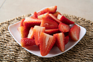 Close-up of white square plate with chopped strawberries