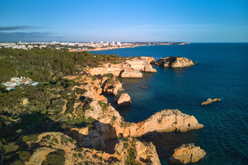 Panoramic view of the limestone cliffs in the foreground and Portimao city in the background, Portugal