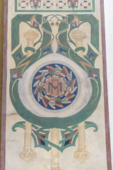 Large green and white painting with a circle in the middle and the letters M