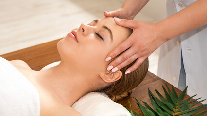 Masseuse hands massaging girl face. Woman closed eyes with pleasure, close up