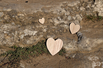 Three wooden hearts in a natural environment of stone and rock