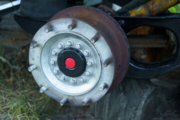 Rusty wheel hub showcasing intricate design details on an abandoned vehicle