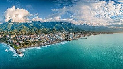 Obraz premium Panoramic aerial photography captures Batumi's cityscape and the vast Black Sea. The backdrop features the towering mountains of Mountain Adjara, framing the bustling seaport below.