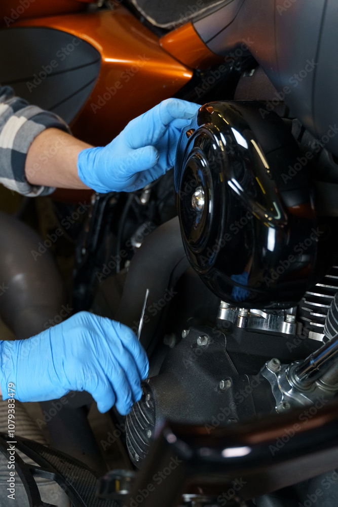 Poster hands-on motorcycle engine maintenance in a workshop during daytime hours
