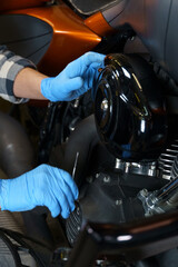 Hands-on motorcycle engine maintenance in a workshop during daytime hours
