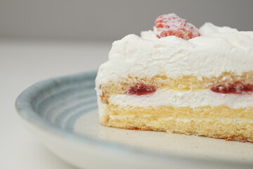 One small Japanese strawberry shortcake on a stylish Japanese plate on a white table