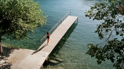 A serene moment on a sunlit dock as a woman contemplates the crystal-clear lake, surrounded by lush greenery.