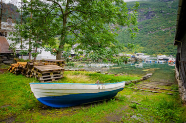 Obraz premium Boat on the coast of Geirangerfjord in town Geiranger, one of the most beautiful fjords in Norway