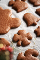Baked gingerbread Christmas cookies on a baking sheet brushed with egg f